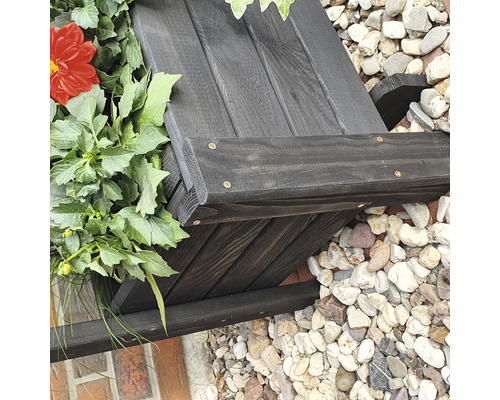 Houten bloembak met planten en stenen op de achtergrond