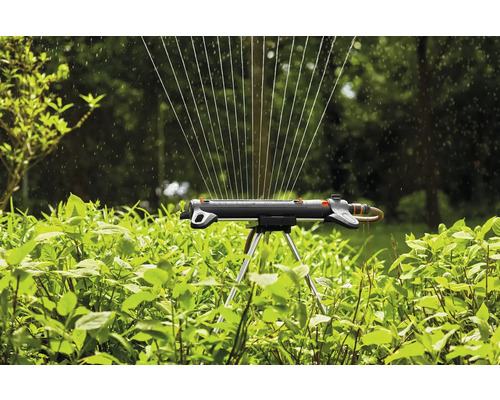 Gazonsproeier met sproeistraal in gebruik om planten te besproeien