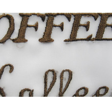 Detail van geborduurde stof met het woord koffie