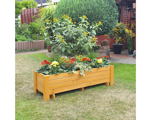 Houten bloembak met bloemen in de tuin