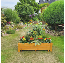 Houten bloembak met bloemen in een tuin