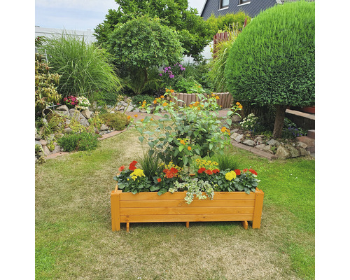 Houten bloembak met bloemen in een tuin