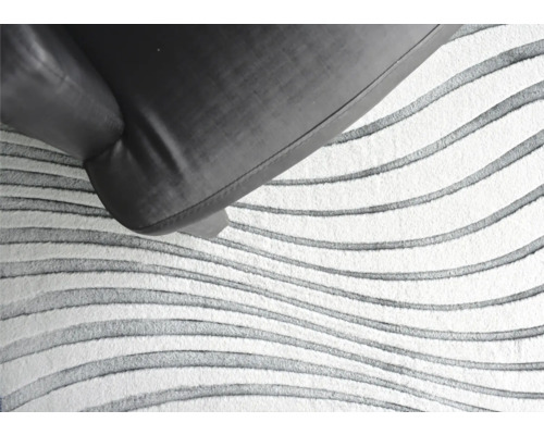 Detail van een vloerkleed met golvend patroon en fauteuil