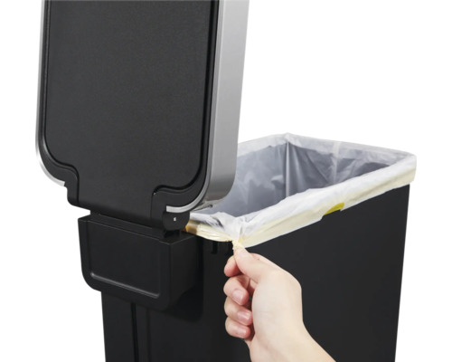 Detailopname van een afvalbak met vuilniszak en hand