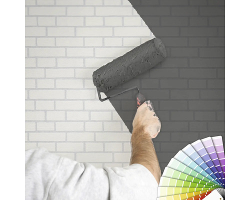 "Iemand schildert een bakstenen muur met een verfroller