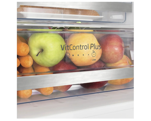 Close-up van een groentelade van een koelkast gevuld met appels en wortelen