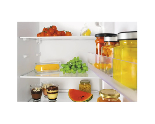 Interieurbeeld van een koelkast met voedingsmiddelen zoals tomaten, druiven, watermeloen en glazen met desserts