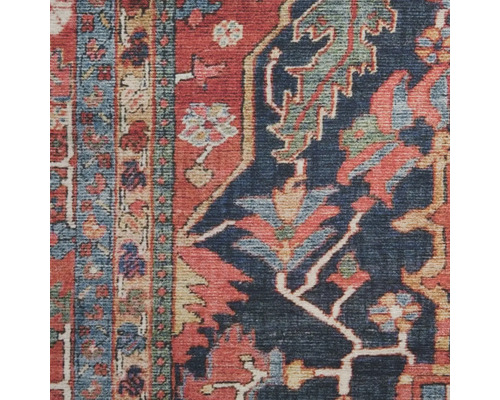 Detailopname van een vloerkleed met een patroon met bloemen- en oosterse motieven.