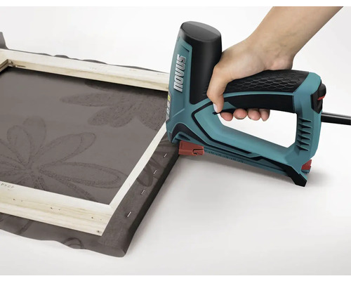 Een hand gebruikt een elektrische tacker om stof op een frame vast te nieten