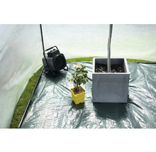 Interieur van kas met verwarming en planten in potten