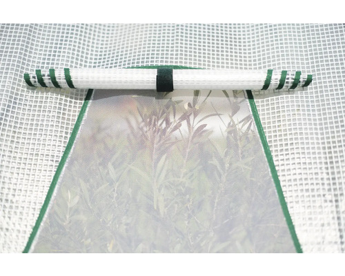 Detailopname van een kas met een open raam en een opgerold rolgordijn.