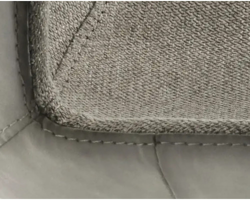 Detailopname van een gestoffeerd meubelstuk met textielbekleding en sierstiksels.