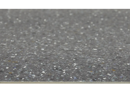 Close-up van een vloertegel met gespikkelde afwerking