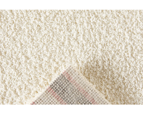 Detailopname van een beige tapijt met hoogpolig oppervlak