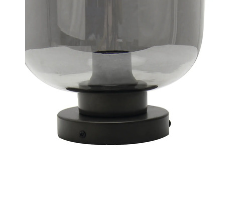 Detailopname van een grijze glazen lamp met zwarte voet