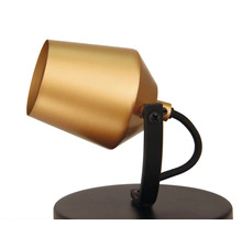 Goudkleurige lamp met zwarte voet voor binnenverlichting