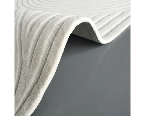 Gedetailleerd beeld van een beige tapijt met een golvend patroon