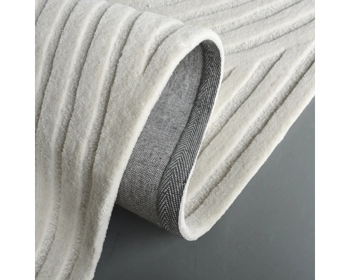 Detailweergave van een lichtgekleurd tapijt met geribbelde textuur.