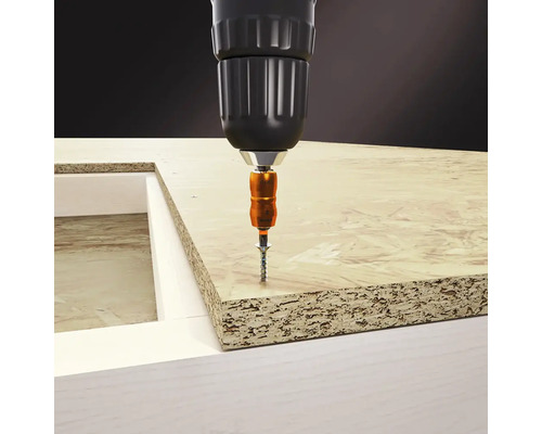 Schroef wordt met een accuschroevendraaier in een houten plaat geschroefd.