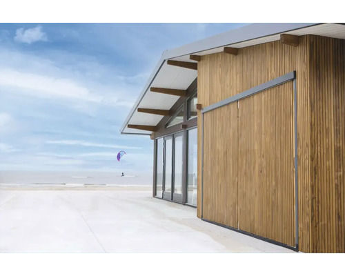 Modern houten huis aan het strand met houten gevel en schuifdeuren