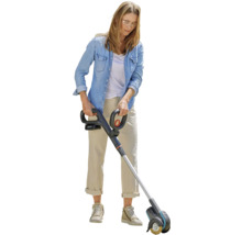 Vrouw gebruikt een accu voegenreiniger in de tuin.