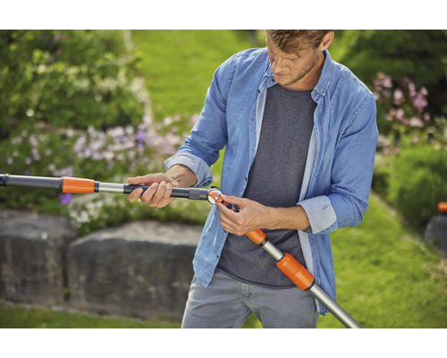 Man stelt een Gardena telescopische steelverlenging voor tuingereedschap af in de tuin.