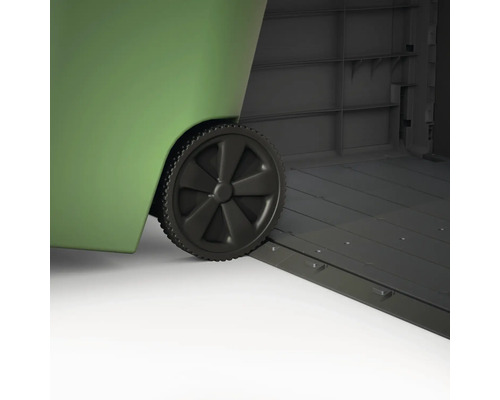 Detailopname van een groene afvalcontainer met wielen, staand in een grijze gereedschapsschuur