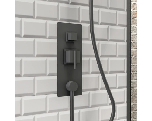 Zwarte douchearmatuur op een witte wand met rechthoekige tegels