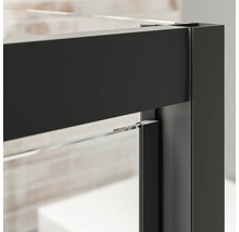 Detailopname van een douchecabine met zwart frame en helder glas