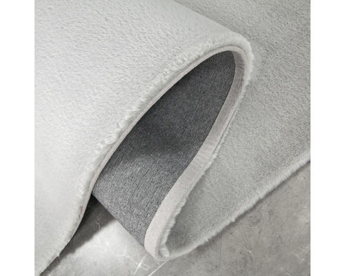 Detailweergave van een lichtgekleurd vloerkleed met pool
