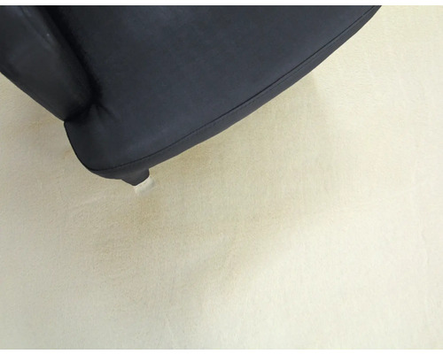 Detail van een zwarte fauteuil met voet
