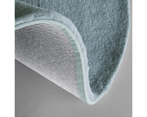 Detailweergave van een rond vloerkleed met pool en geweven rug