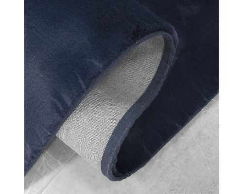 Detailopname van een donkerblauw tapijt met een textielen rug
