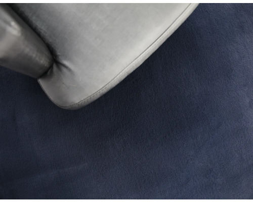 Detailopname van een grijze stoel op een blauw tapijt