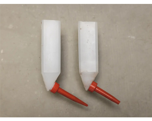 Twee dierendrinkbakken van kunststof met rode nippel