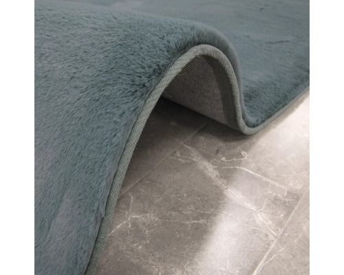 Close-up van een vloerkleed met pool op een betegelde vloer.