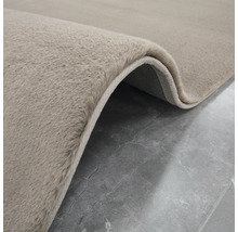Detailopname van een beige tapijt met hoogpolig oppervlak