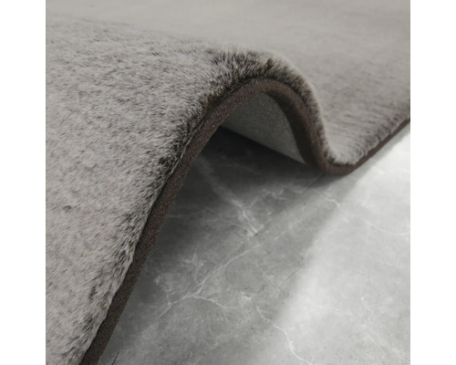 Close-up van een grijs vloerkleed met een bruine rand