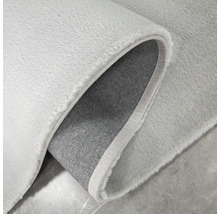 Detailopname van een lichtgekleurd vloerkleed met een textielen rug