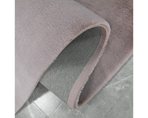 Detailopname van een lichtgekleurd vloerkleed met hoogpolig oppervlak