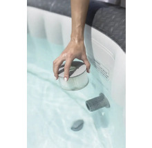 Een hand houdt een filter in een bubbelbad.