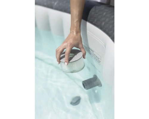 Een hand houdt een filter in een bubbelbad.