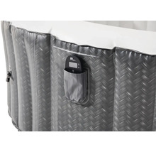 Detail van een grijs opblaasbaar bubbelbad met bedieningselement in een zak