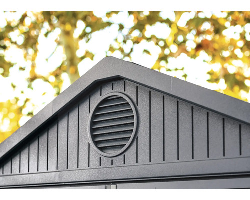 Detail van een tuinhuis met een rond ventilatierooster onder het dak
