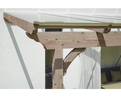 Detail van een houten pergola tegen een huismuur