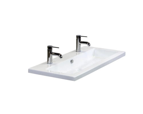 Witte keramische wastafel met twee kranen