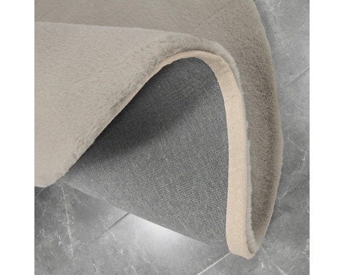 Detailopname van een vloerkleed met pooloppervlak en geweven achterkant