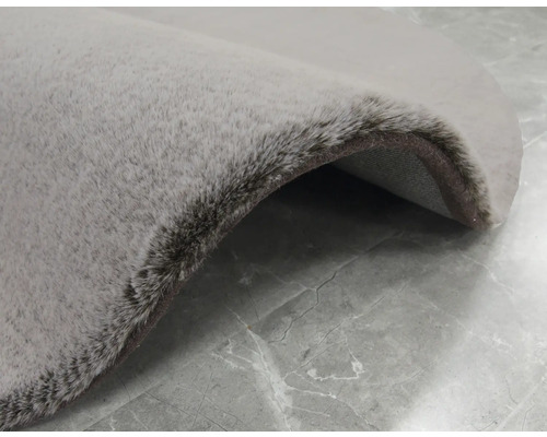 Detailweergave van een rond, lichtgekleurd vloerkleed met pool