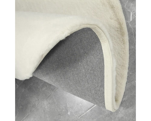 Detailweergave van een rond vloerkleed met pool en geweven achterkant