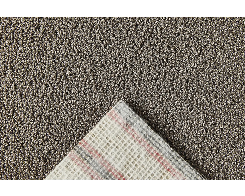 Detailopname van een tapijt met lussenstructuur en geweven rug